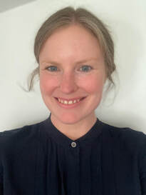 Photo of a smiling woman wearing a black blouse